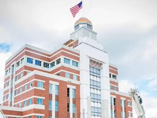 A large building with an american flag on top of it.