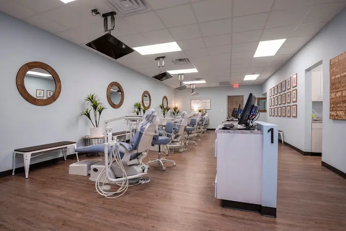 A room filled with many dental chairs and equipment.