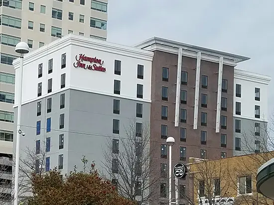 A hotel with many windows and buildings in the background.